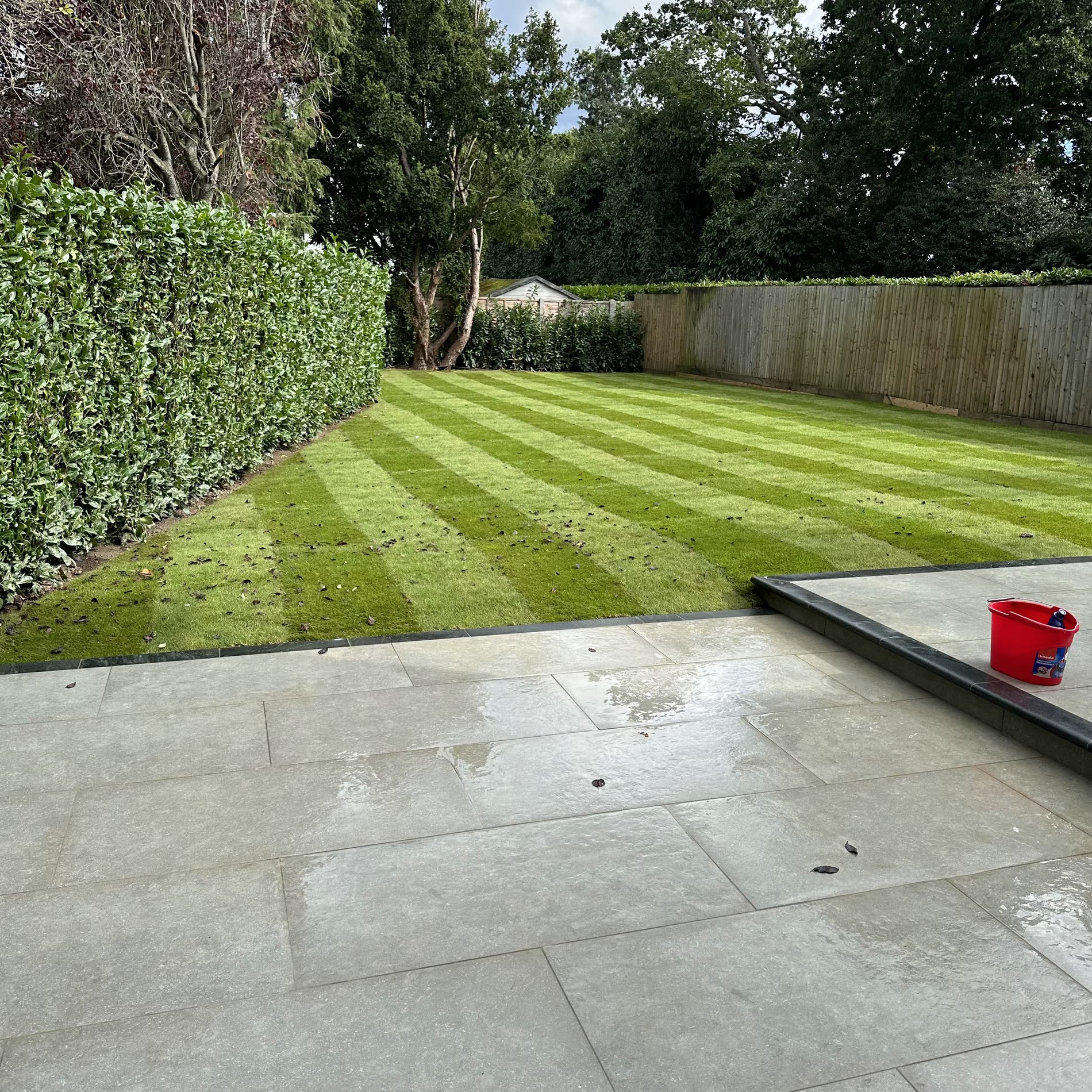 Porcelain patio laid level, with steps and a clean retaining wall.