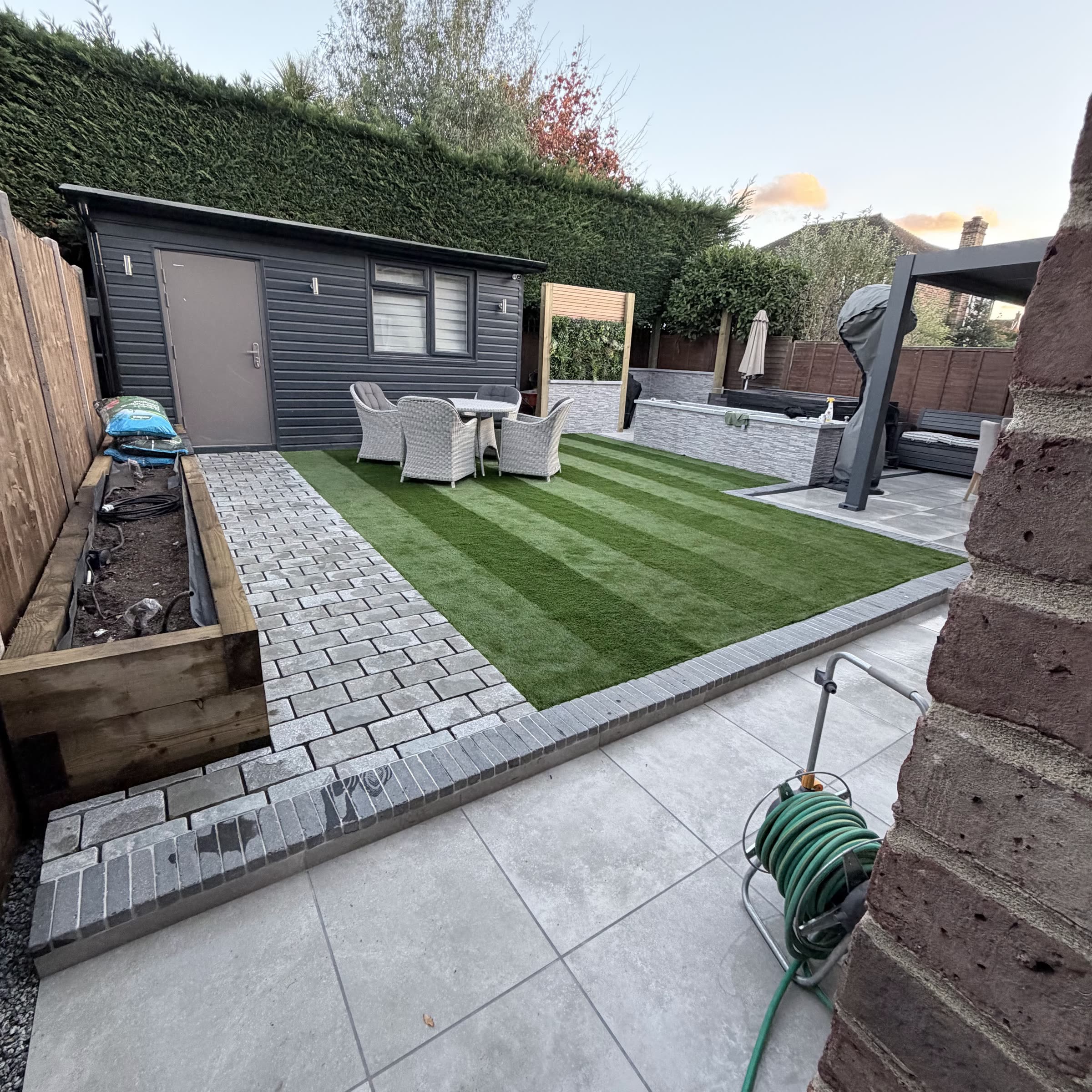 A Surrey garden transformed by LG Pro Landscaping — fresh striped lawn, porcelain patio and planted borders